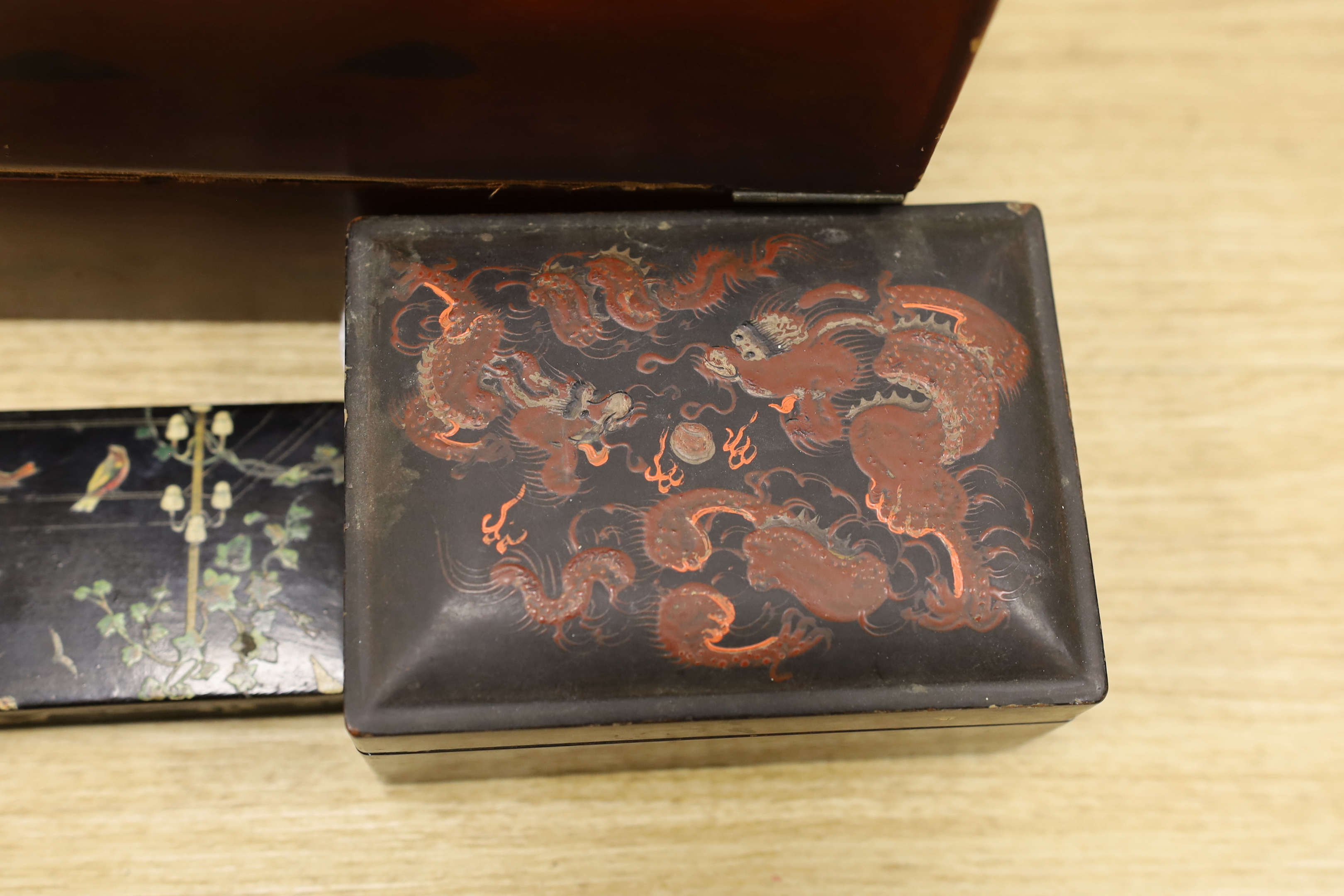 A Japanese lacquer writing box and three black lacquer or papier mache boxes